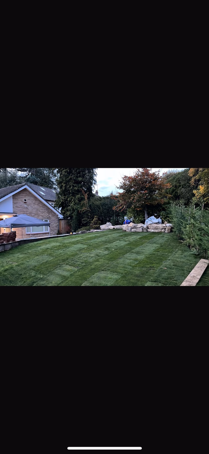 Lawn-led garden with boulder feature